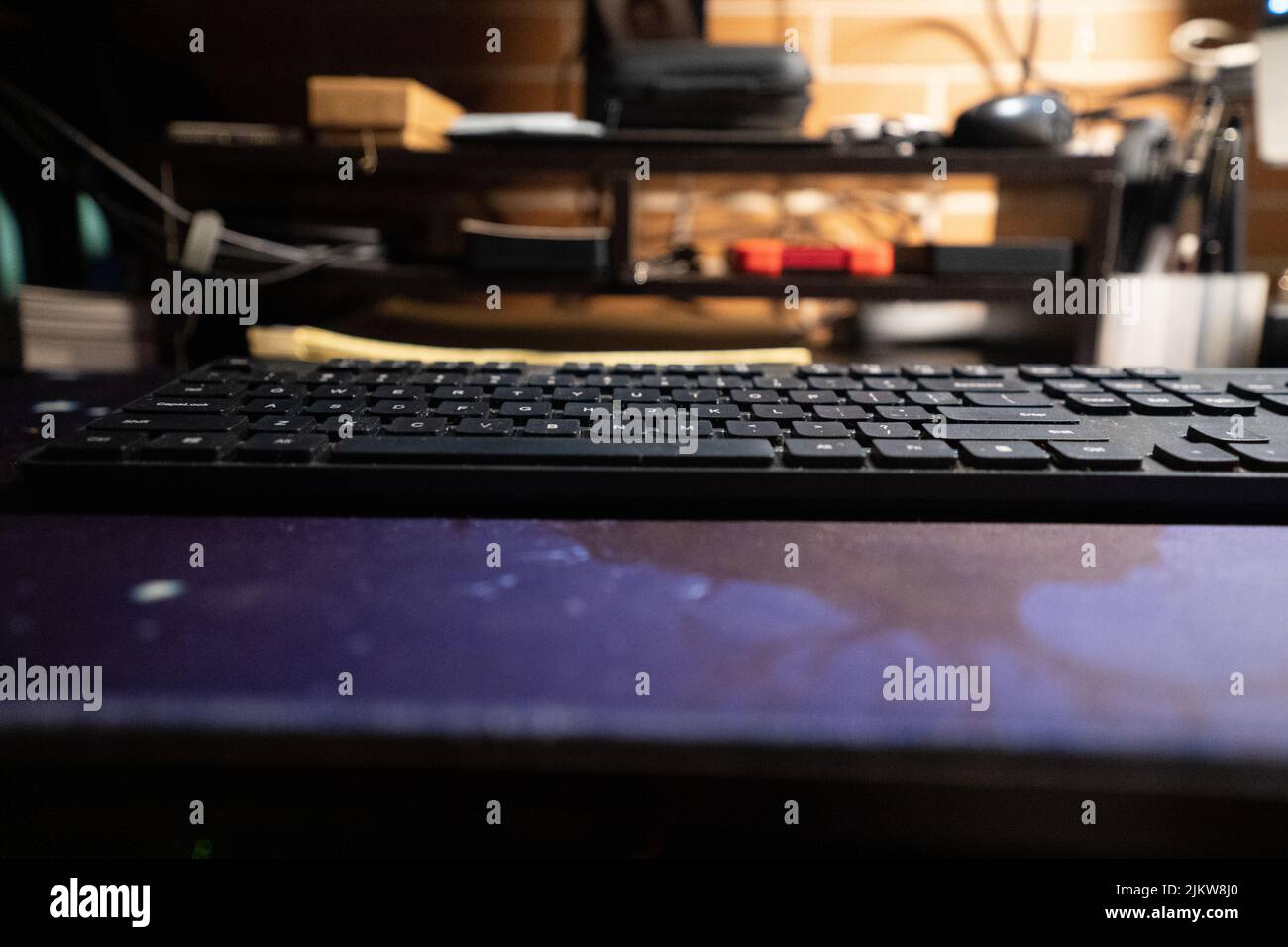 Tastiera nera di un computer su un tavolo su uno sfondo sfocato Foto Stock