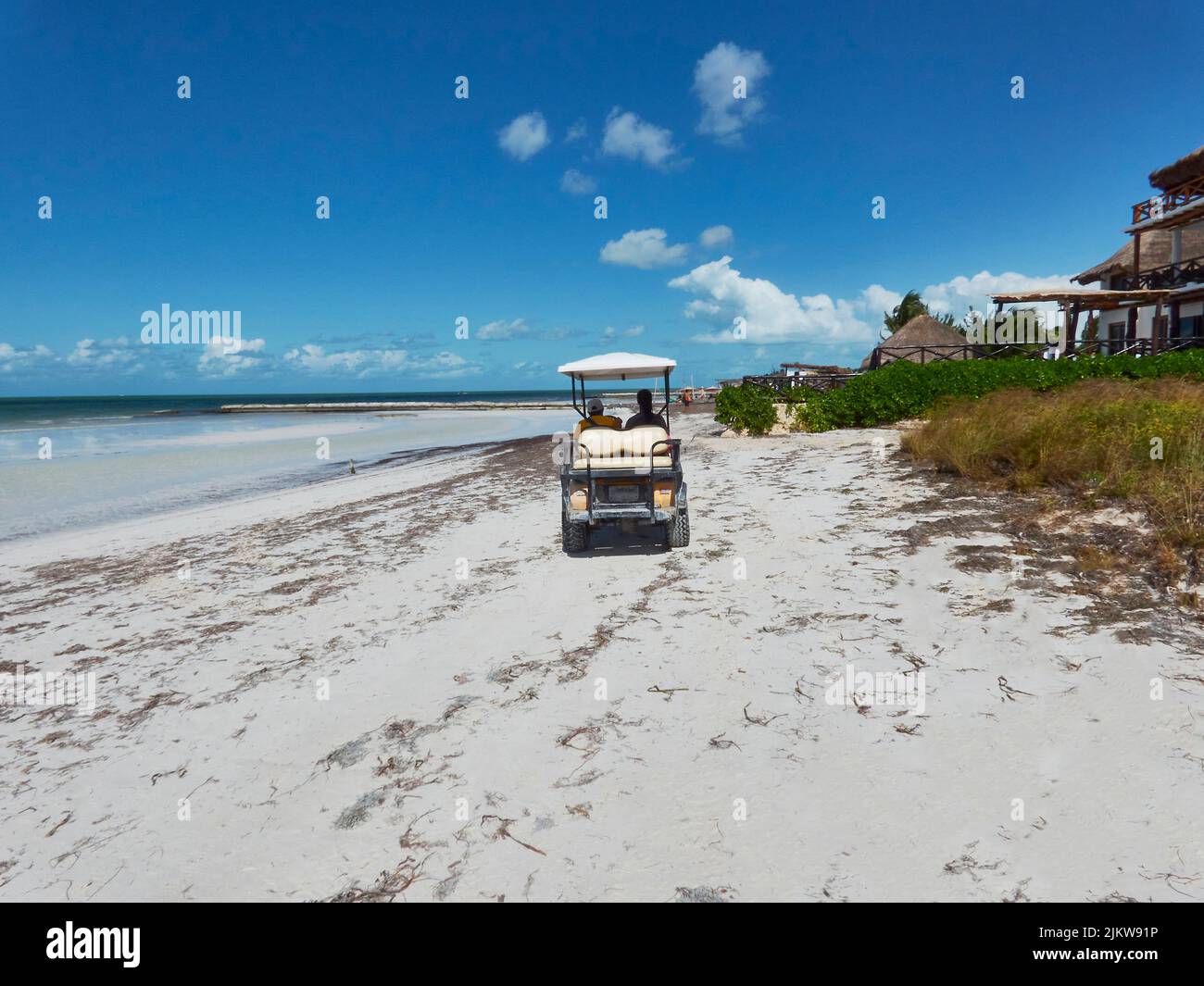 golf cart che trasporta i turisti su una spiaggia paradisiaca nei caraibi Foto Stock