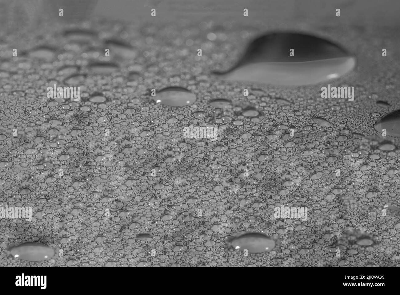 Una vista di una superficie grezza con gocce d'acqua su di essa creando una texture interessante Foto Stock
