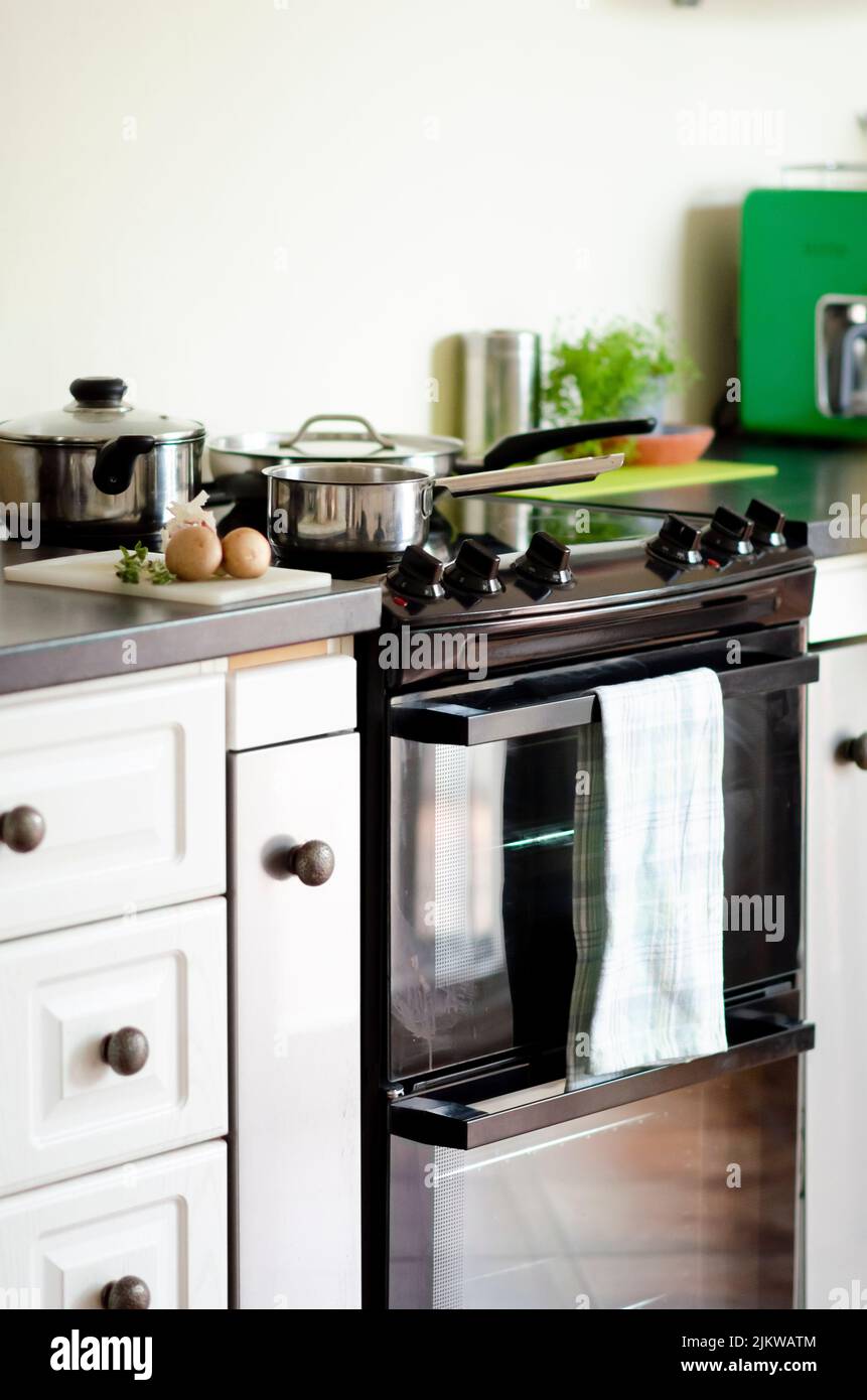 Una cucina con forno e vari utensili da cucina e padelle Foto Stock