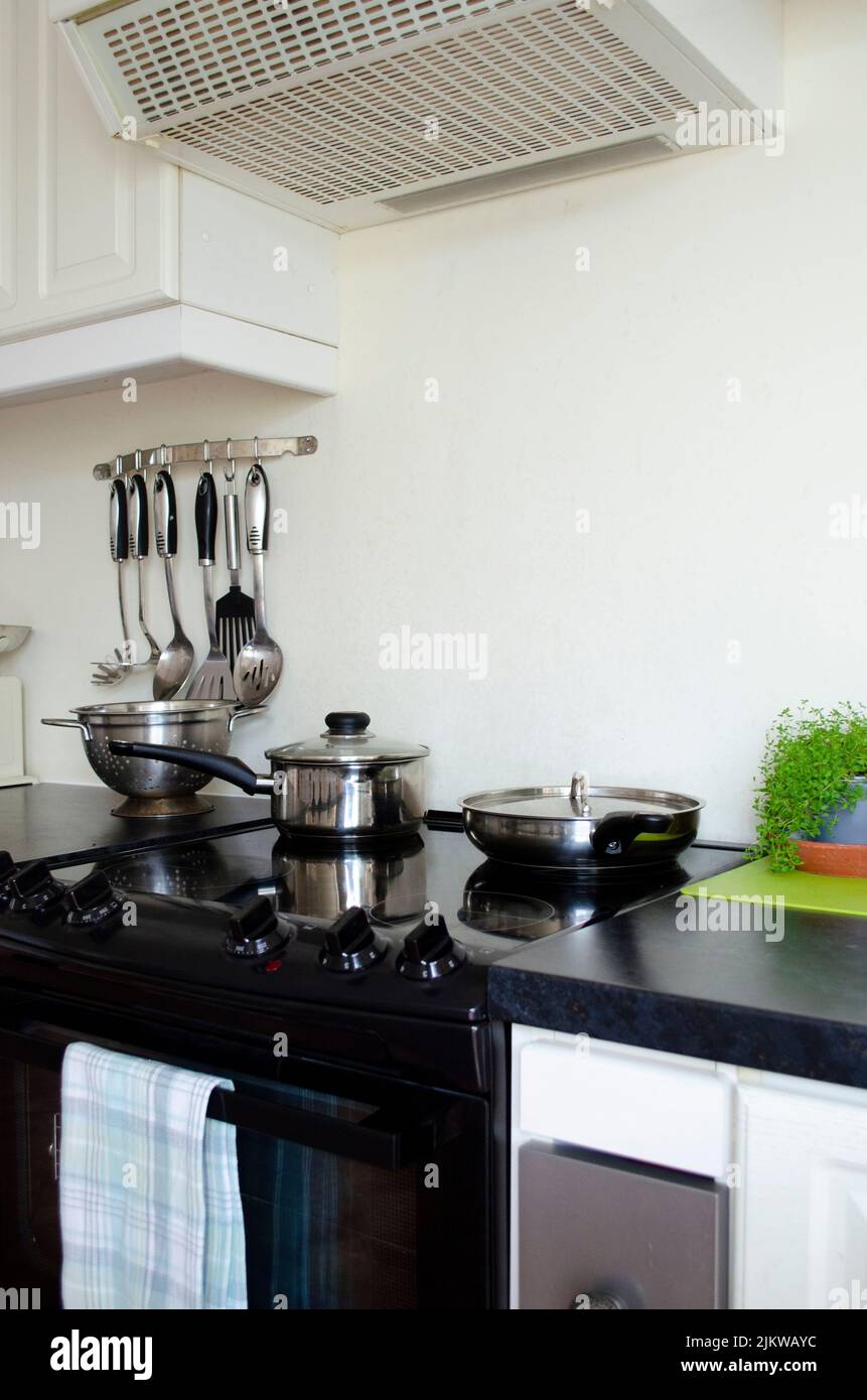 Una cucina con forno e vari utensili da cucina e padelle Foto Stock