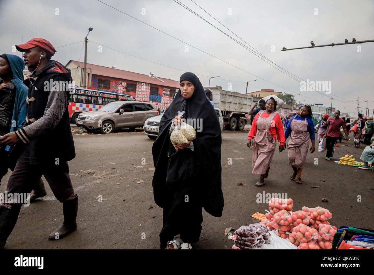 I pedoni passano accanto ai falchi che vendono i loro prodotti per le strade del quartiere centrale degli affari di Nairobi in Kenya. La maggior parte delle scuole keniote erano su Augus Foto Stock