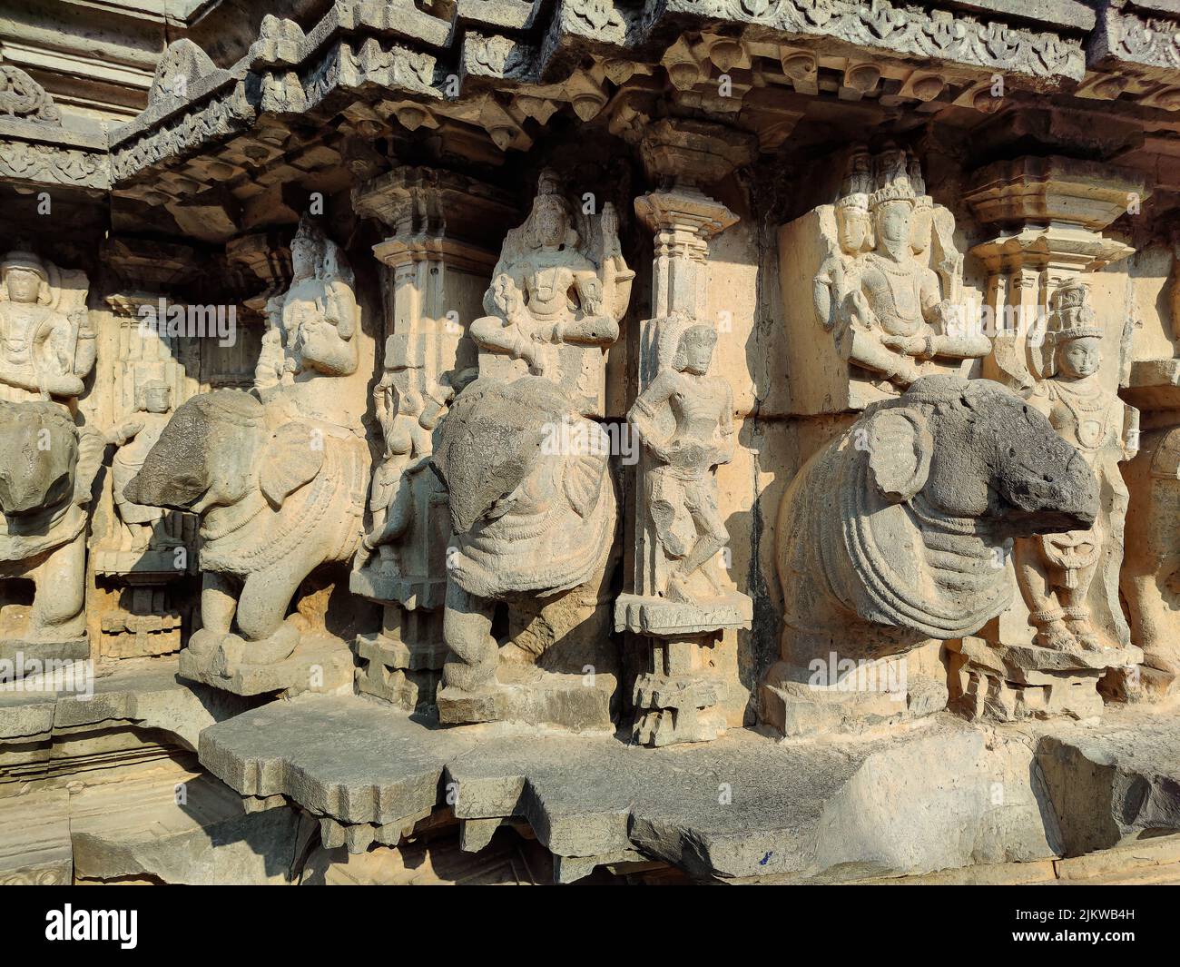 Foto di scorta di scultura antica rovinata di Dio della trinità indù seduto su elefante, idolo scolpito fuori gary colore granito luce del sole cadere su idolo, Pic Foto Stock