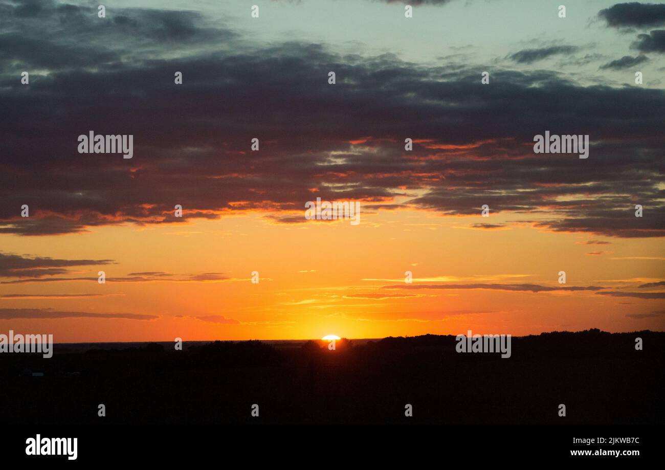 Una bella vista del tramonto rossastro con cielo nuvoloso sullo sfondo Foto Stock