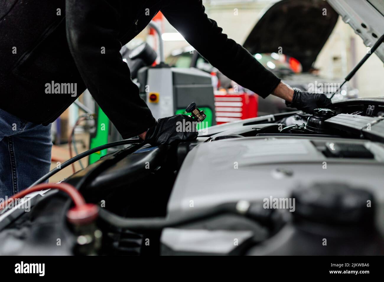 Meccanico professionale che si serve di aria condizionata per auto. Negozio di riparazione auto. Foto Stock