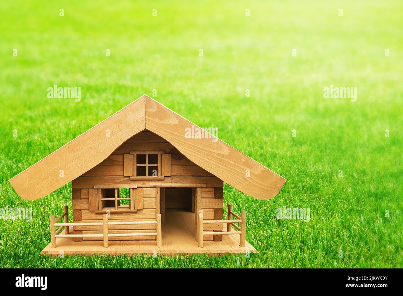 Un modello di casa privata in legno su erba verde - concetto di proprietà di lettura Foto Stock