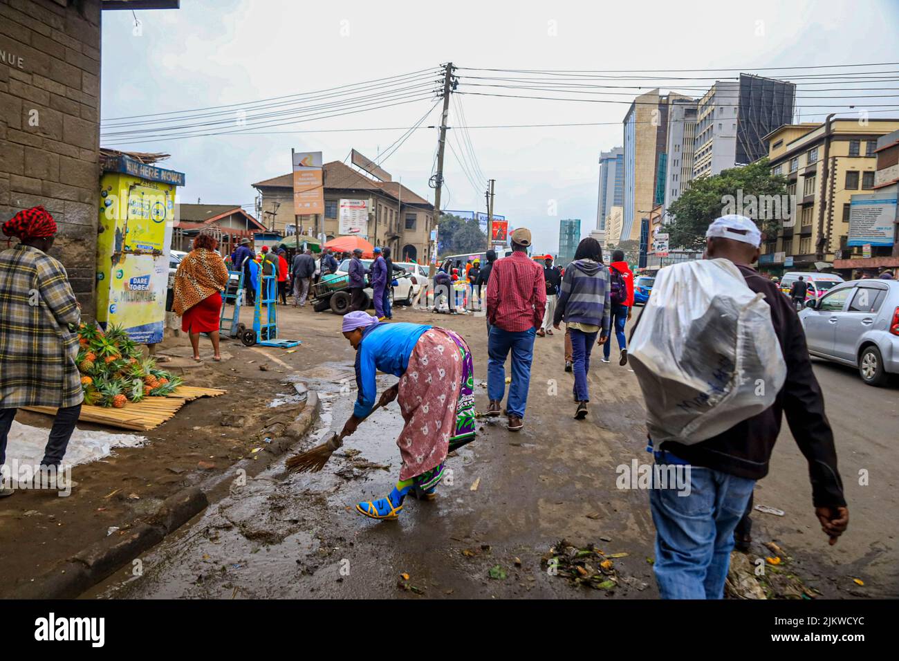 I pedoni passano accanto ai falchi che vendono i loro prodotti per le strade del quartiere centrale degli affari di Nairobi in Kenya. La maggior parte delle scuole keniote erano su Augus Foto Stock