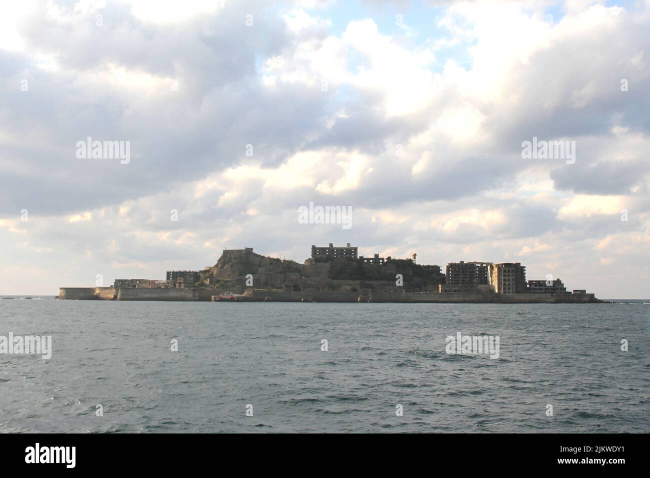 Gunkanshima (Hashima) visto da una barca turistica in una giornata nuvolosa vicino a Nagsaki in Giappone Foto Stock