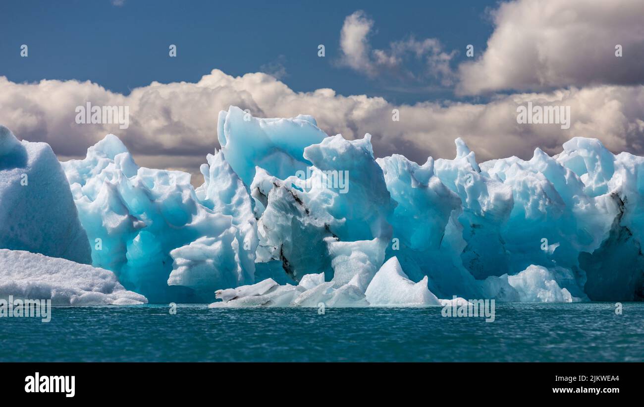 Il Vatnajokull sull'Islanda, ghiaccio che scorre sull'acqua, uccelli che volano intorno, giorno di sole ma gelido Foto Stock
