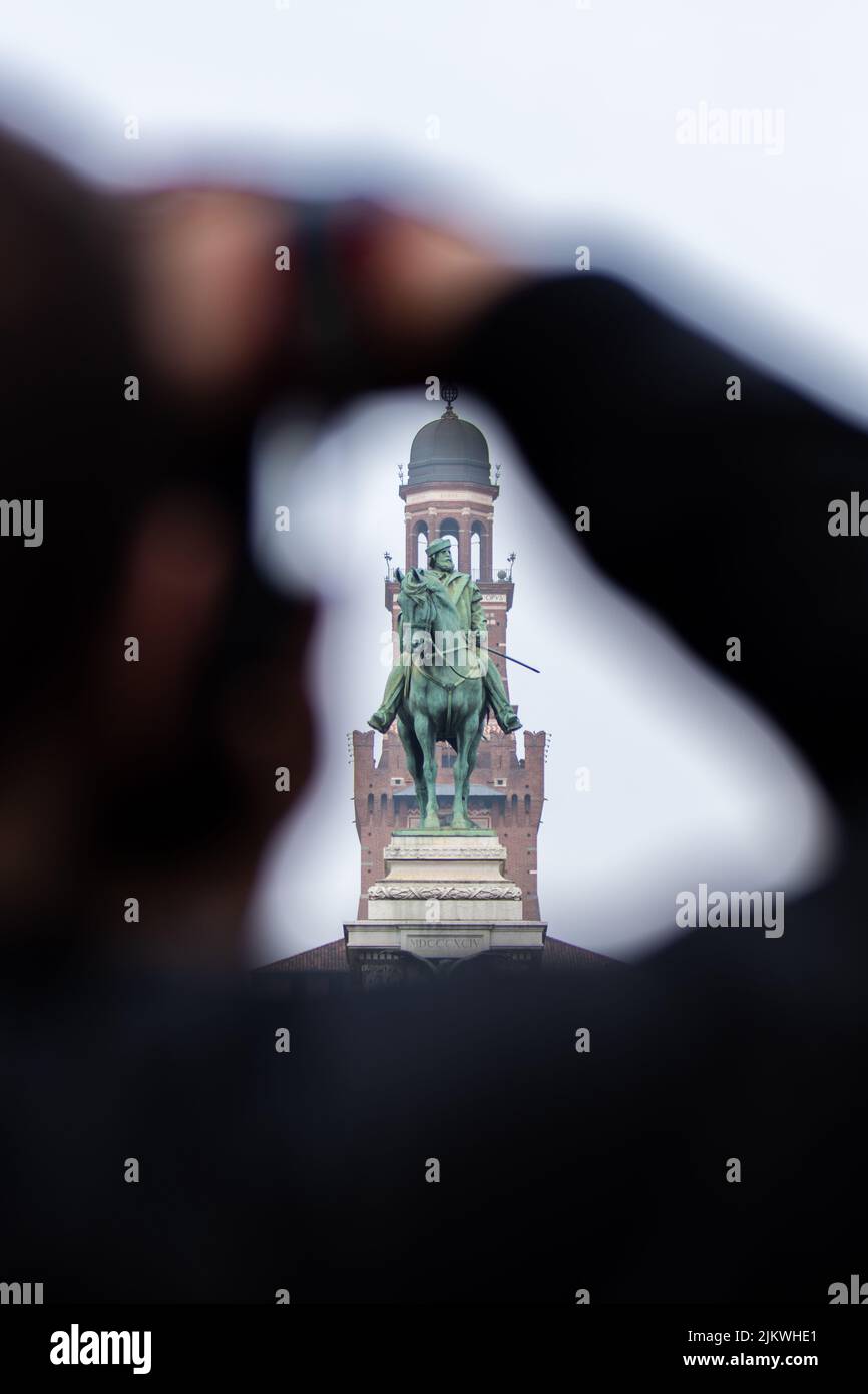Un uomo sfocato che fotografa il monumento in bronzo a Giuseppe Garibaldi a Piazzale Carioli, Italia Foto Stock