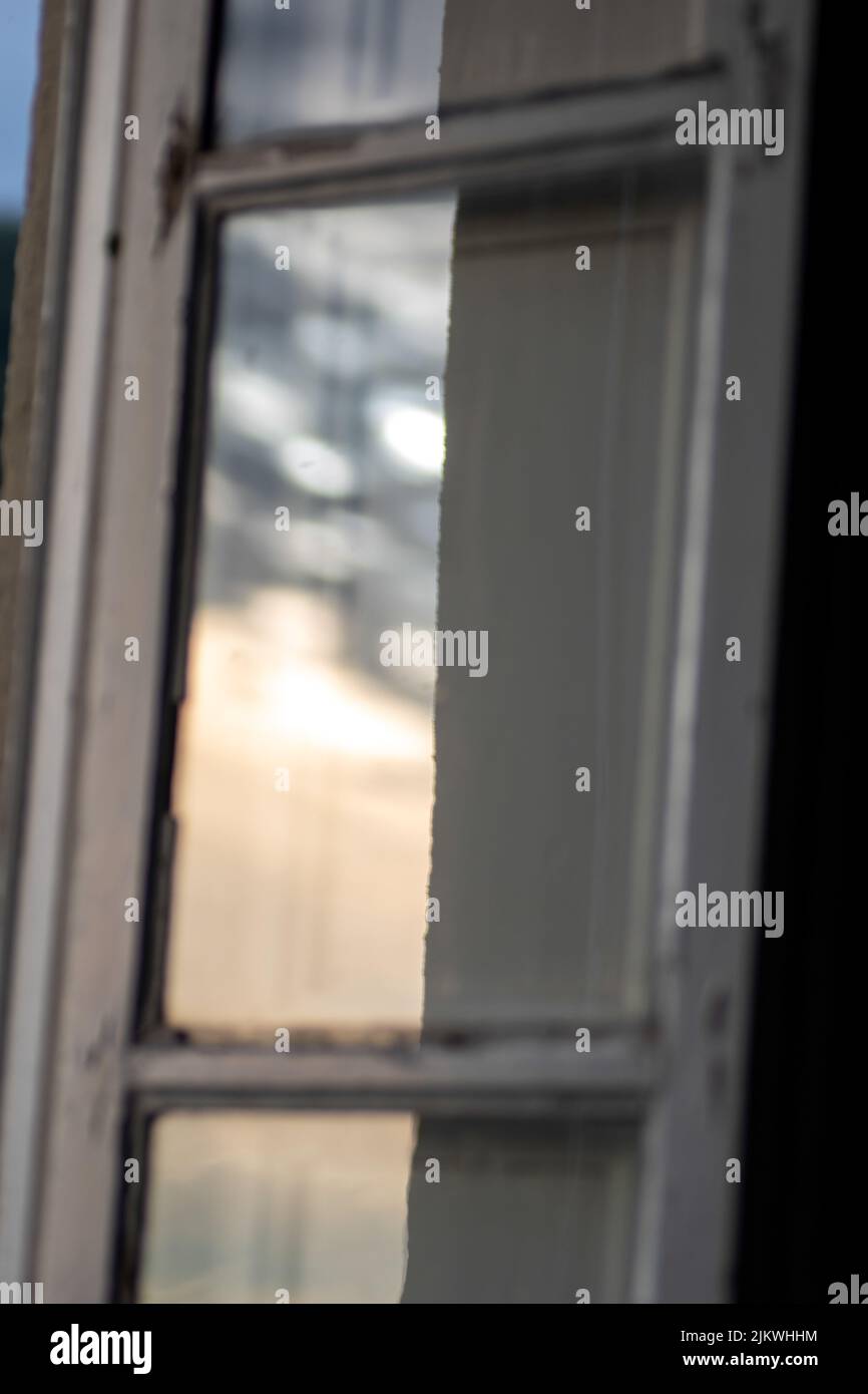Uno scatto verticale di una vecchia finestra di vetro al tramonto Foto Stock