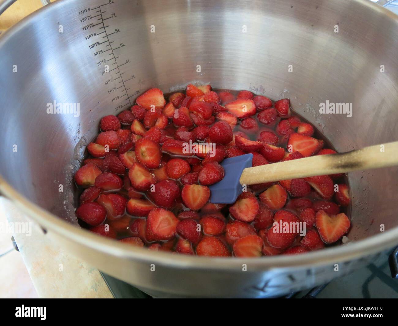 Gusto d'estate: Dopo aver seminato per una notte con zucchero, queste fragole vengono mescolate delicatamente prima di bollire rapidamente per fare la marmellata di fragole. Foto Stock