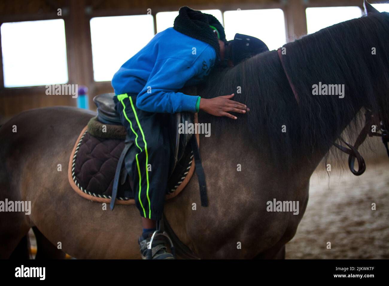 Sessione di Equitherapy per un autistico in un centro equestre. Foto Stock