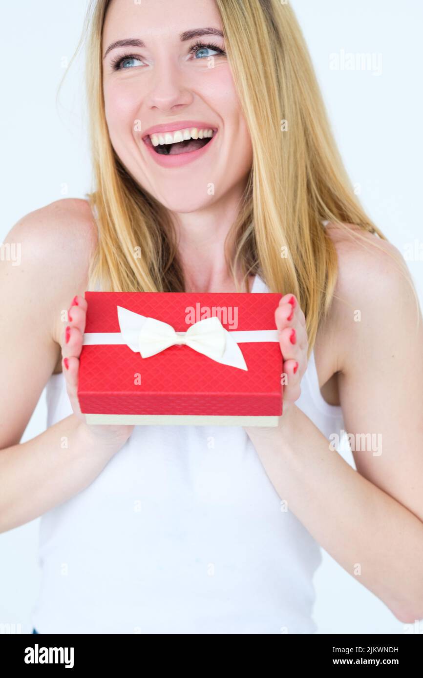 felice gioioso sorriso donna tenere rosso regalo scatola ricompensa Foto Stock
