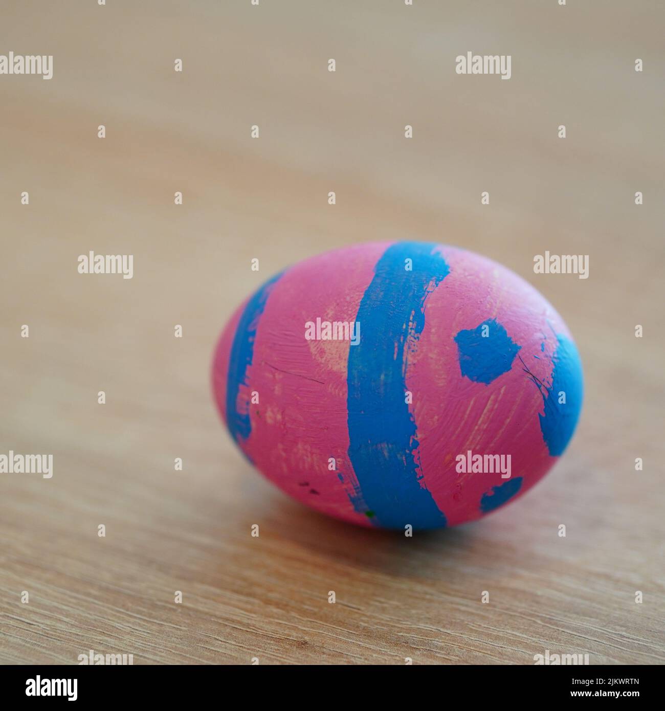 Un primo piano di un colorato uovo di pasqua dipinto su un tavolo di legno Foto Stock
