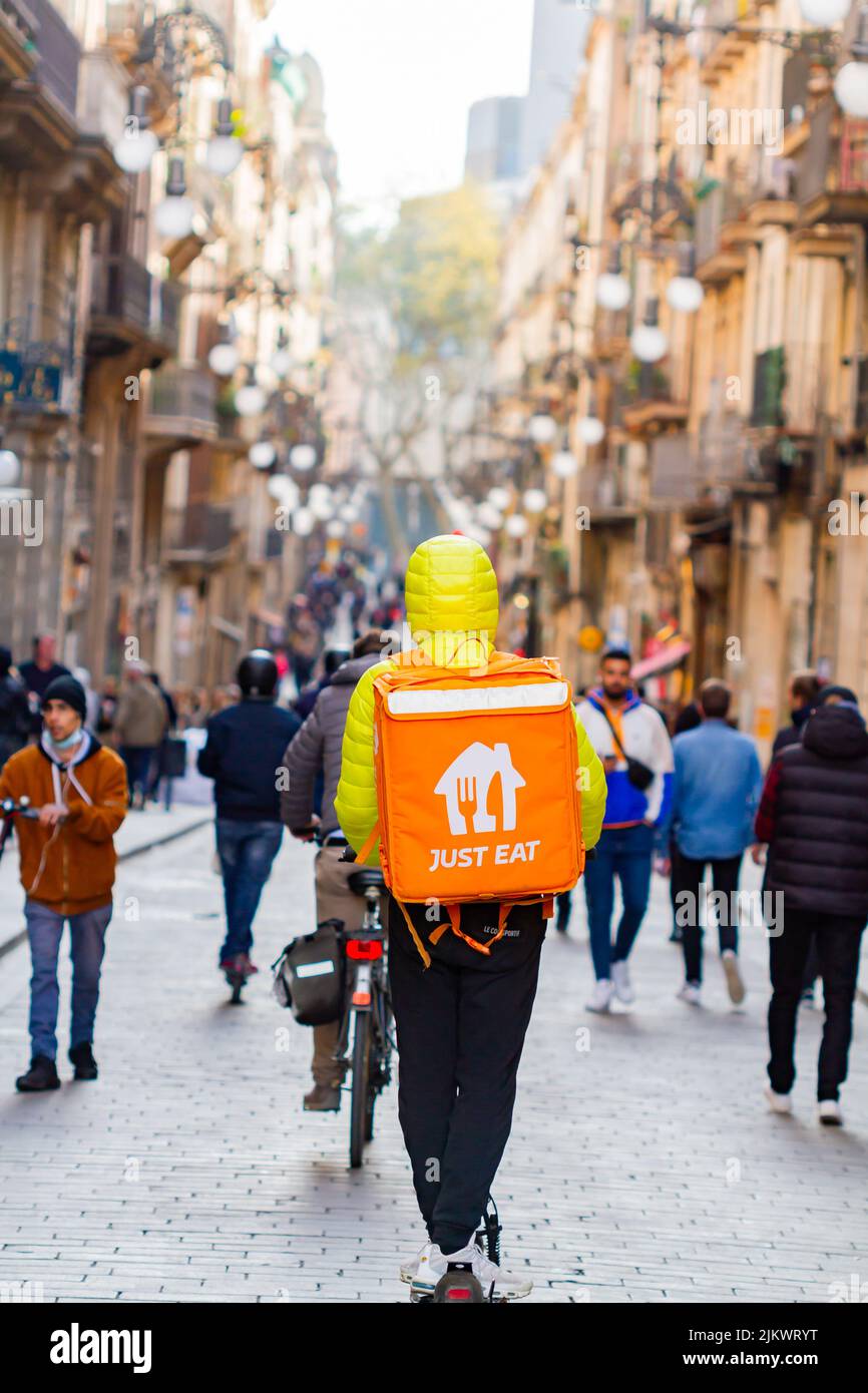 Barcellona, Spagna - 4 aprile 2022: Consegna di fast food ( Just Eat) con scooter nel quartiere gotico di Barcellona (Spagna), approccio selettivo - Foto Stock