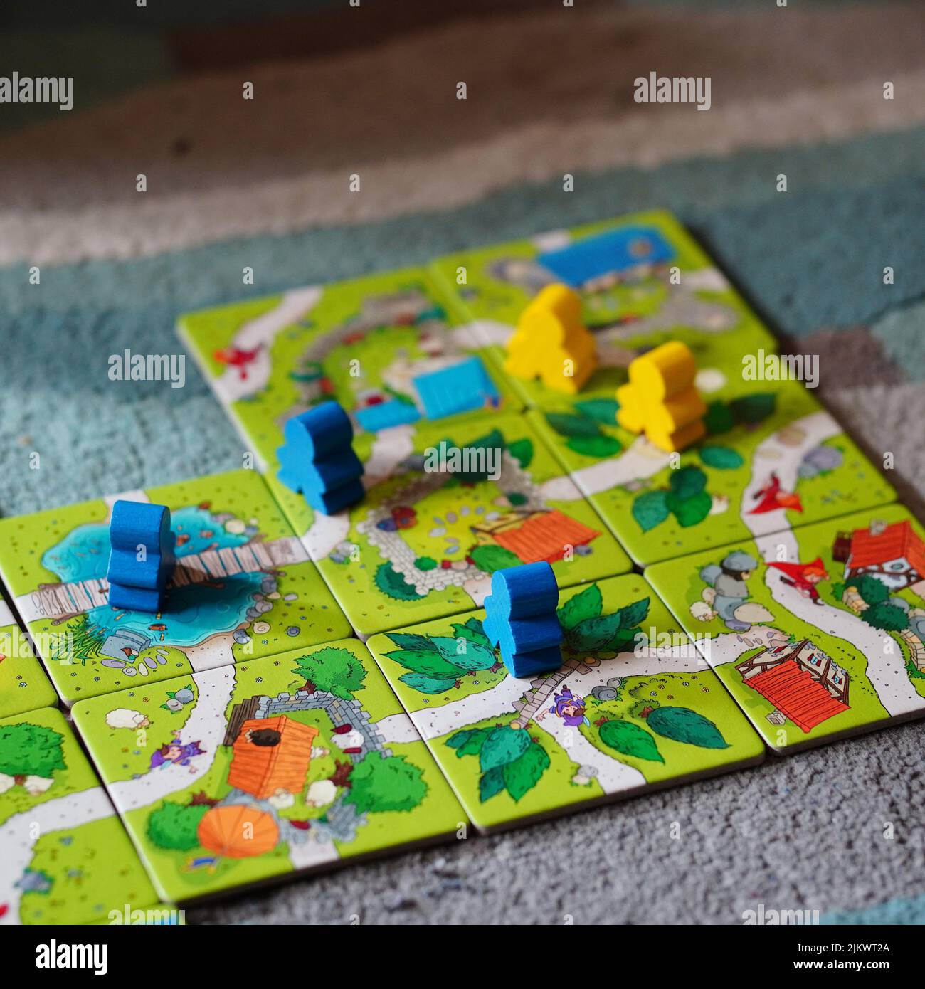 Figurine in piedi su una mappa fatta di carte del Mindok Carcassonne Junior gioco da tavolo Foto Stock