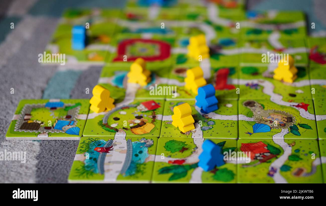 Figurine in piedi su una mappa fatta di carte del Mindok Carcassonne Junior gioco da tavolo Foto Stock