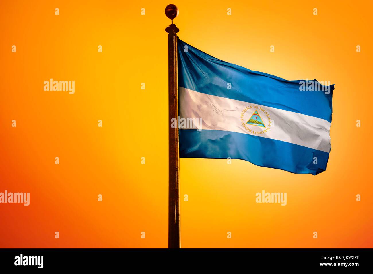 La bandiera nazionale di El Salvador su un flagpole isolato su uno sfondo arancione Foto Stock