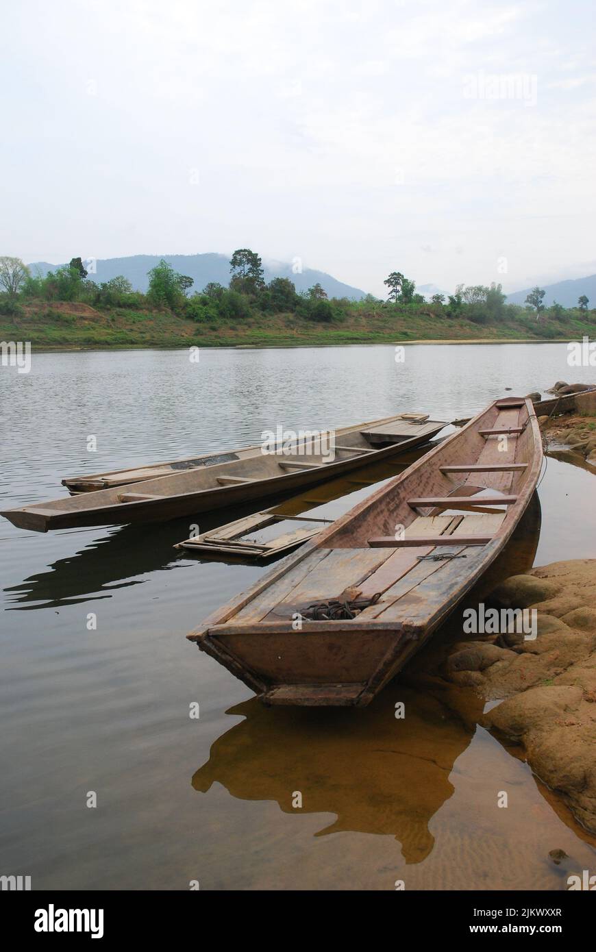 Barche da pesca in legno ancorate sul lato del fiume Mekong in Laos, Asia Foto Stock