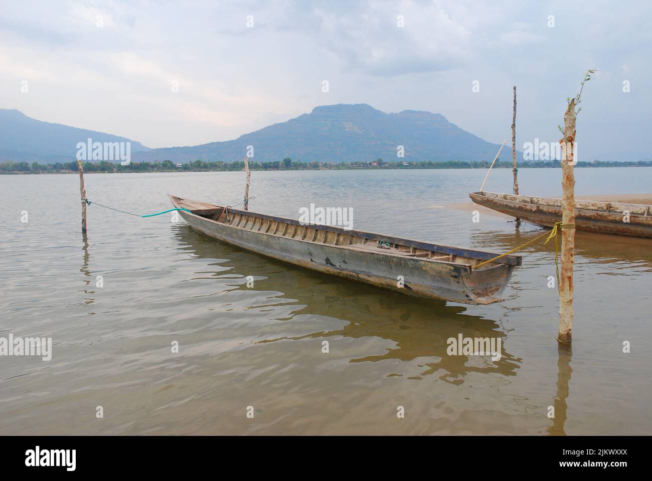 Barche da pesca in legno ancorate sul lato del fiume Mekong in Laos, Asia Foto Stock