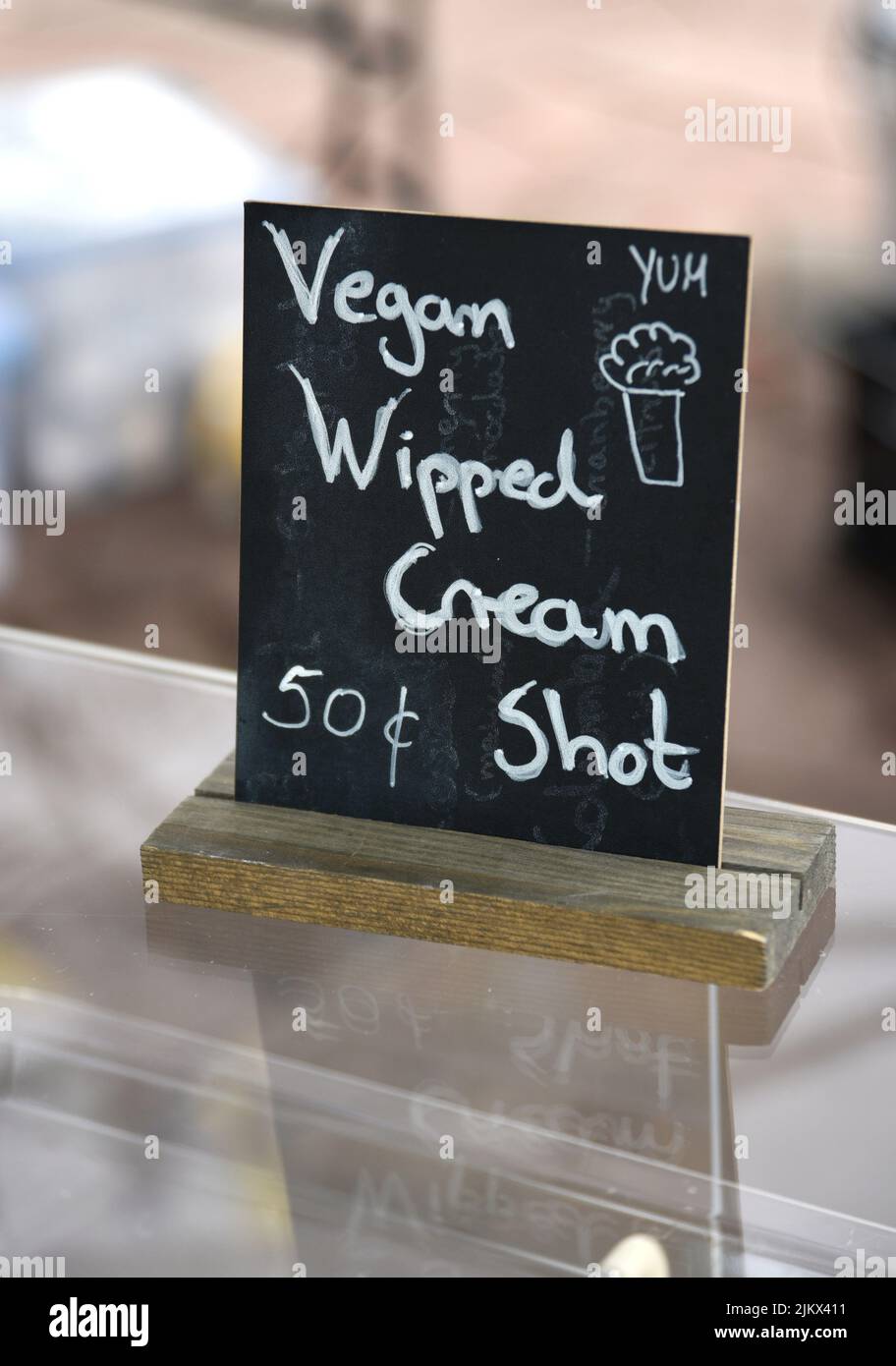 Un fornitore di cibo offre vegan panna montata shot sui suoi dessert al forno in un festival a Santa Fe, New Mexico. Foto Stock