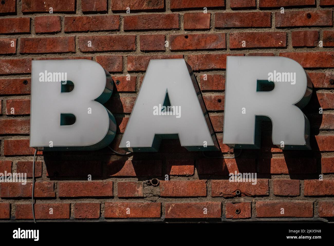 Un primo piano di un cartello che dice barra su un muro di mattoni rossi a Oslo, Norvegia Foto Stock