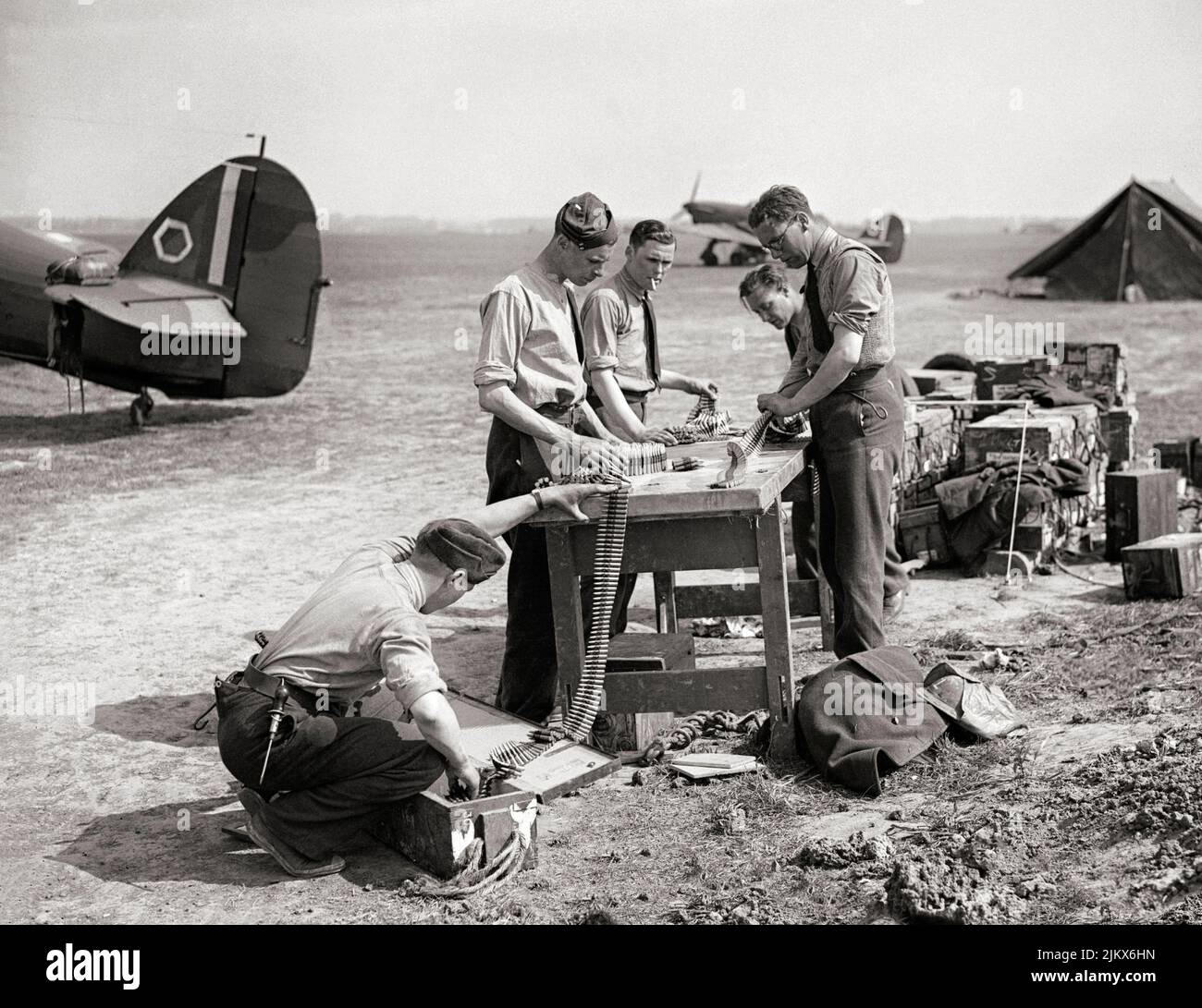 L'equipaggio e gli armatori di terra riempono le munizioni con .303 proiettili di Hawker Hurricane Mark è di No. 85 Squadron RAF a Lille-Seclin, Francia. L'aereo da caccia britannico a posto singolo ha combattuto in tutti i principali teatri della seconda guerra mondiale. Foto Stock