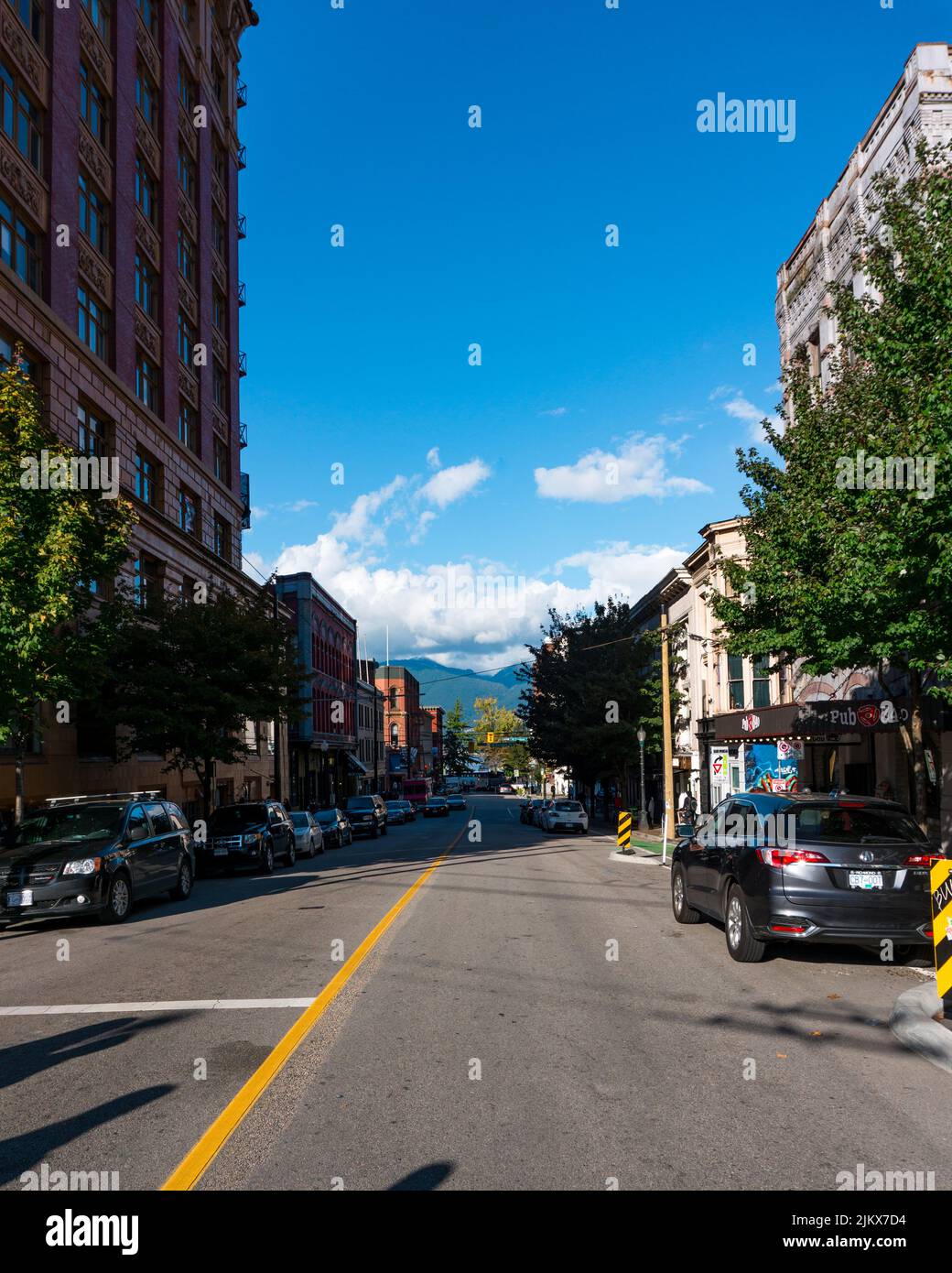 StreetView a Vancouver, British Columbia. Il primo piano mostra una vista media della strada, ma porta ad una vista delle montagne. Foto Stock