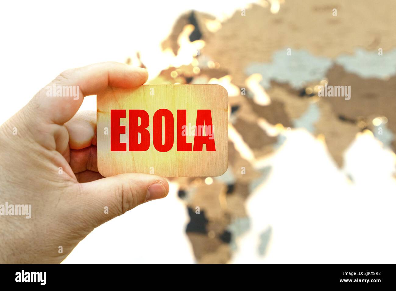 Medicina e concetto di salute. Sullo sfondo della mappa del mondo, un uomo ha un segno con l'iscrizione EBOLA Foto Stock