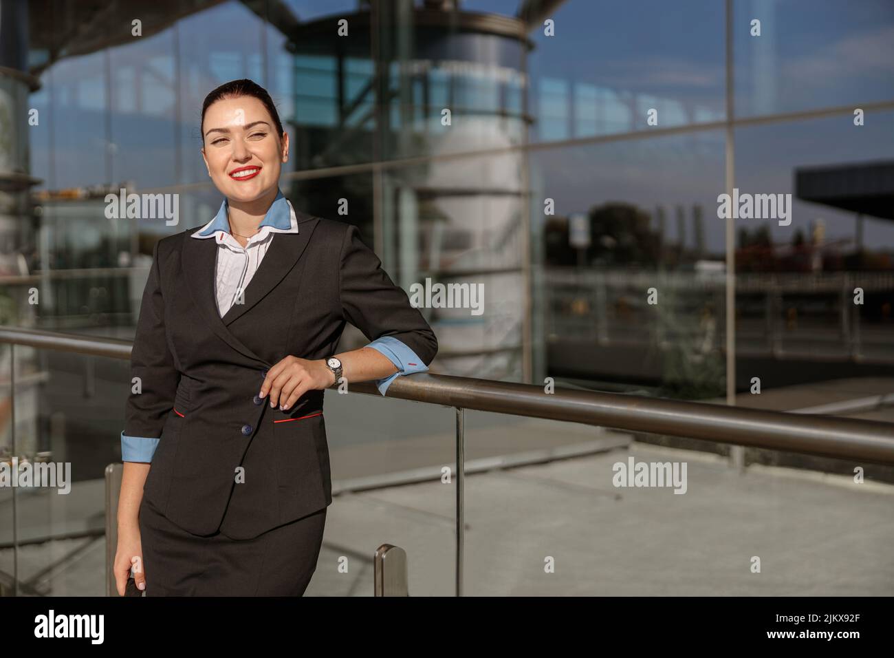 Bella senza stewardess appoggiata su una rastrelliera metallica vicino al terminal all'aperto Foto Stock