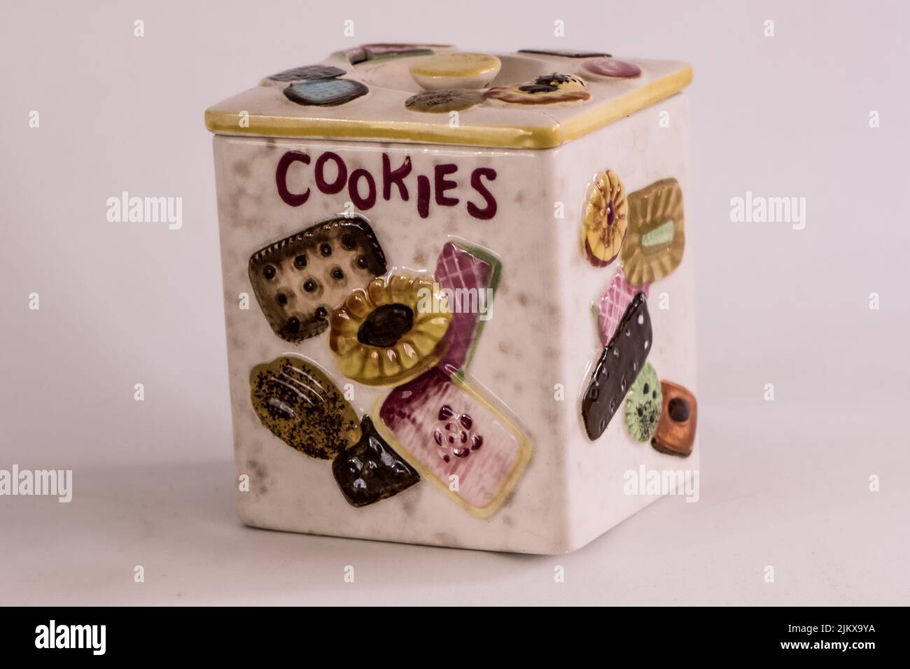 Un primo piano di una graziosa scatola in ceramica con vari dipinti di pasticceria, isolata su sfondo bianco Foto Stock