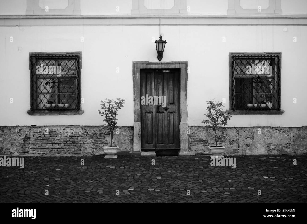 Un'immagine in scala di grigi di una vecchia facciata casa a Sibiu, Transilvania, Romania Foto Stock