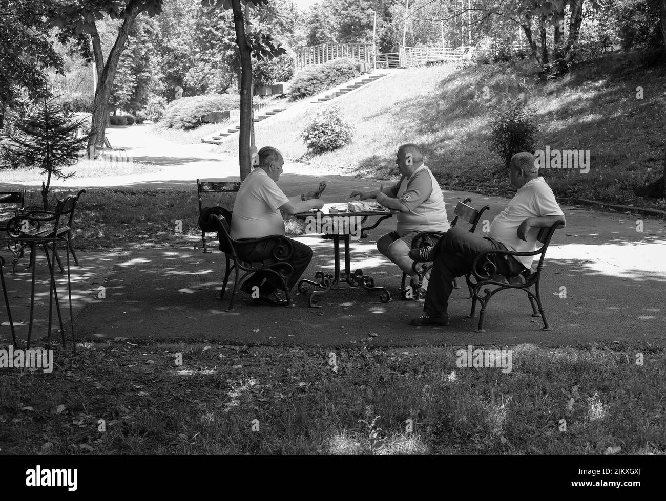 Un colpo in scala di grigi di persone che giocano a scacchi nel Parco Mihai Eminescu ad Arad, Romania Foto Stock