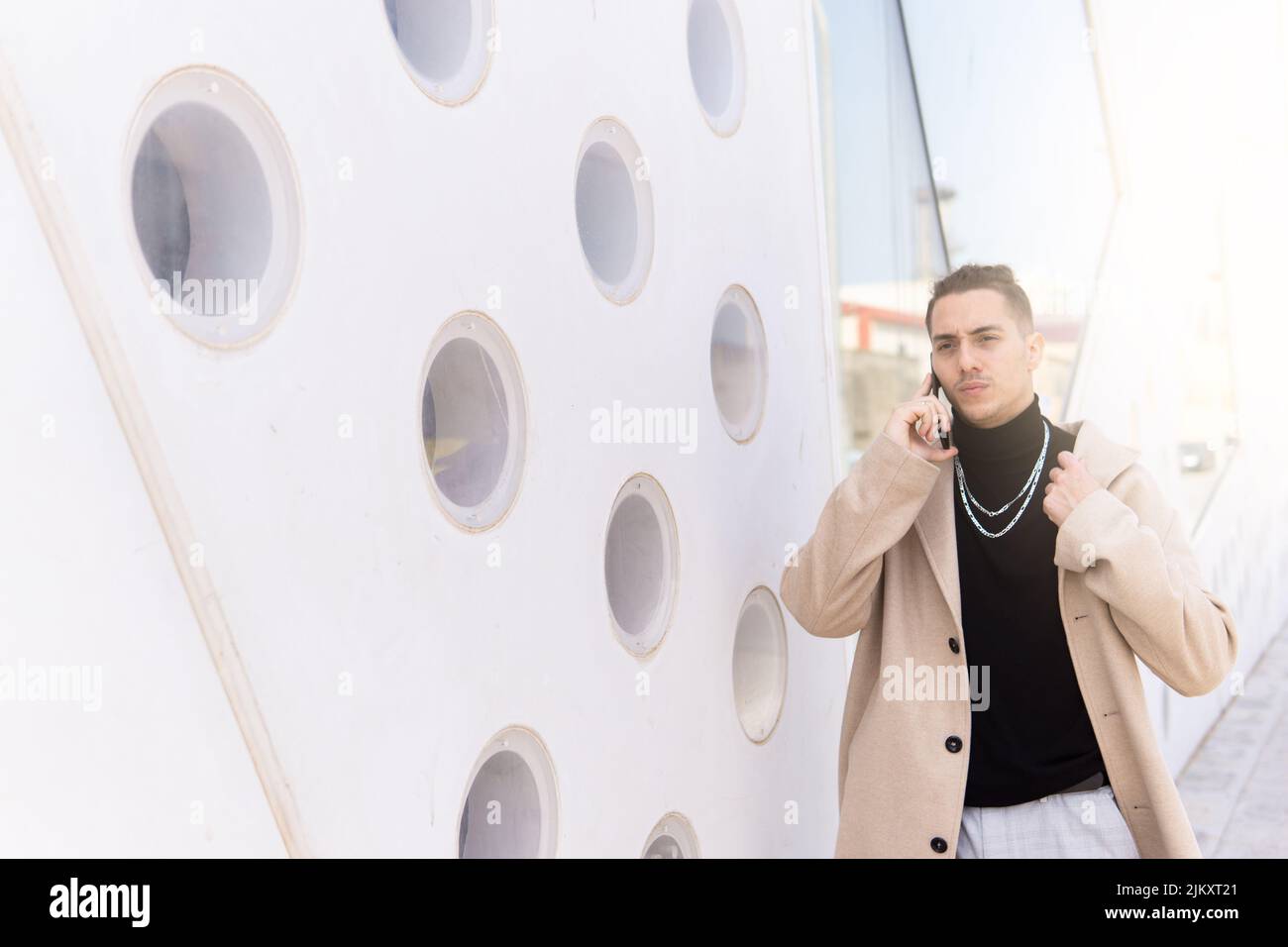 Ritratto di un giovane uomo misto-corsa che parla su uno smartphone in città. Social media, comunicazione, app mobili, business, concetto di stile di vita Foto Stock