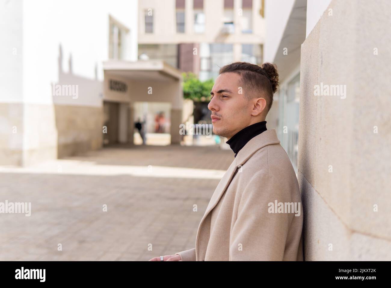 Ritratto di un giovane uomo misto con un aspetto pensivo in città Foto Stock