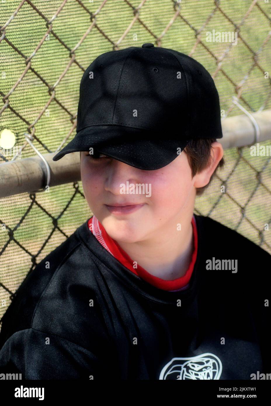 Giovane e rilassato giocatore di baseball che si gode un momento di calma nel dugout. Foto Stock