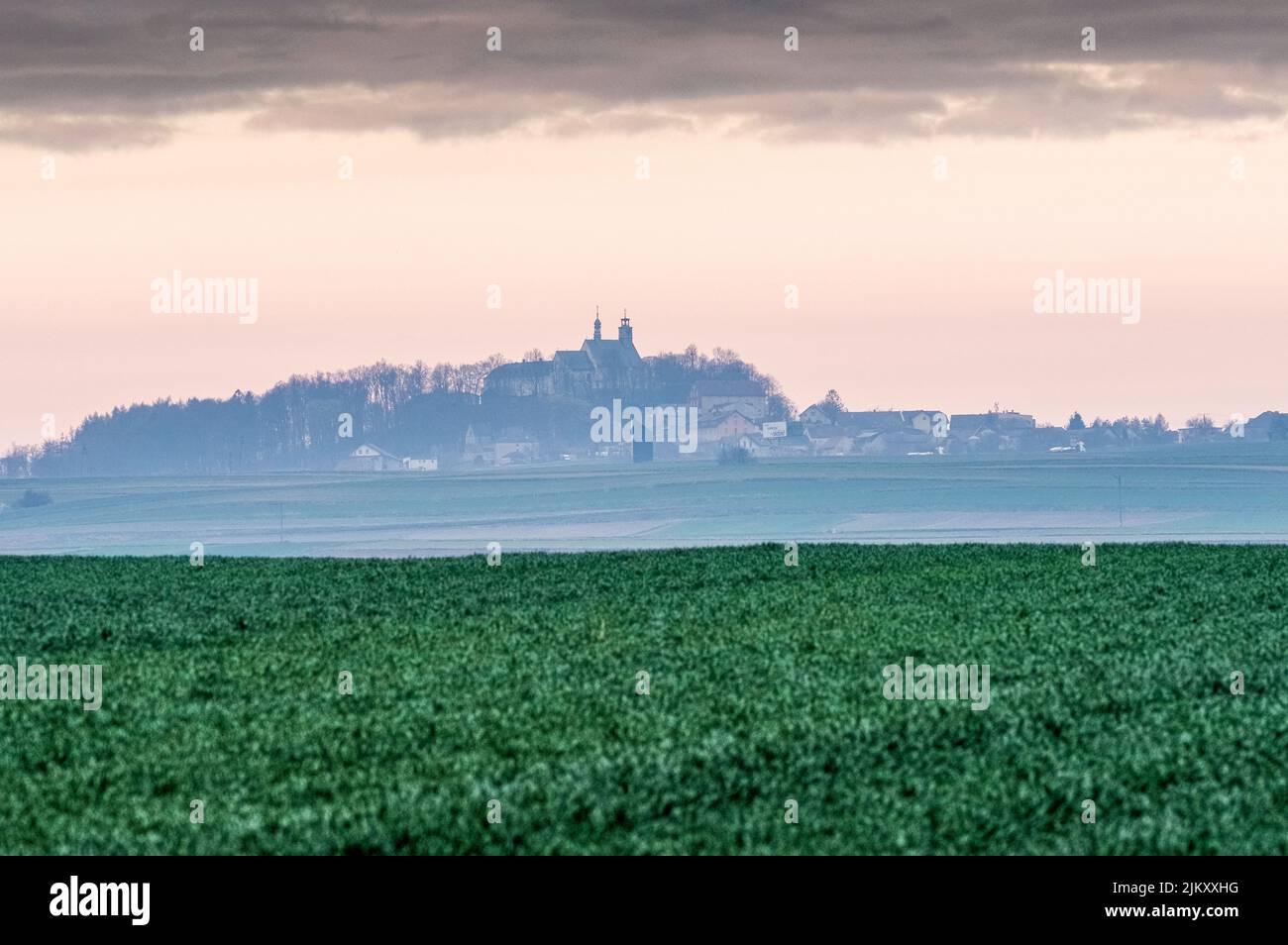Un paesaggio verde con edifici sullo sfondo, Sankt Annaberg, alta Slesia, Polonia Foto Stock