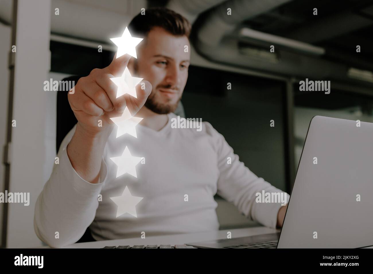 Uomo che dà una valutazione di 5 stelle per un servizio o un prodotto on-line. Foto Stock