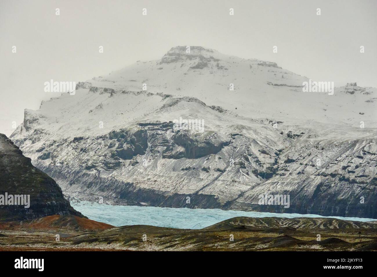 Il ghiacciaio blu si trova sotto la montagna innevata in Islanda Foto Stock