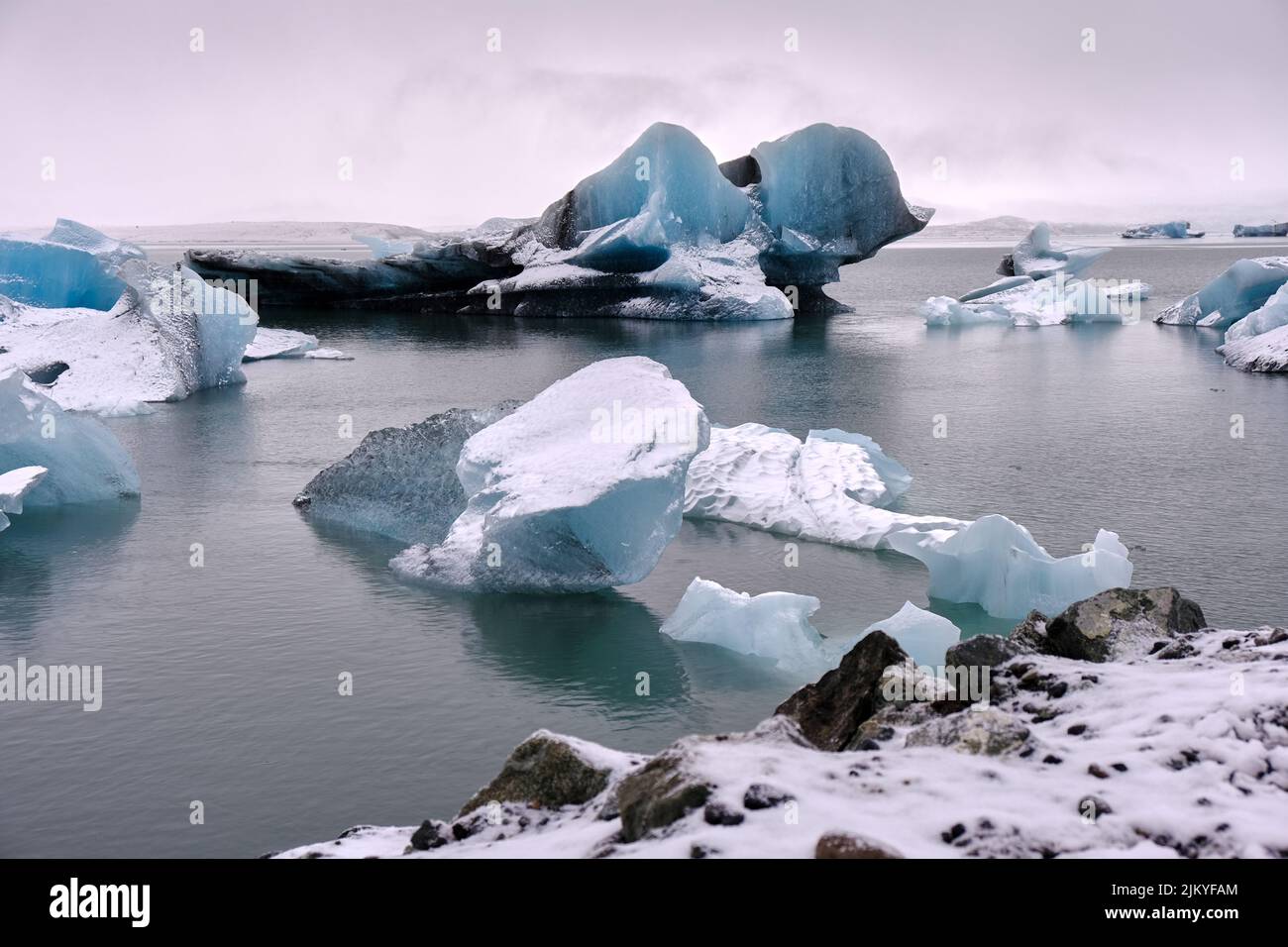Grandi iceberg blu e nero galleggiano sul Lago del Ghiacciaio Fjallsarlon, Islanda. Foto Stock