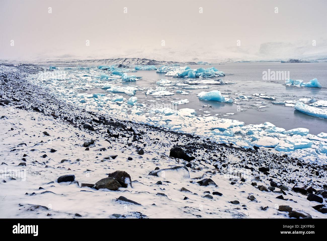 Vista grandangolare del Lago del Ghiacciaio Fjallsarlon, Islanda, con molti iceberg galleggianti Foto Stock