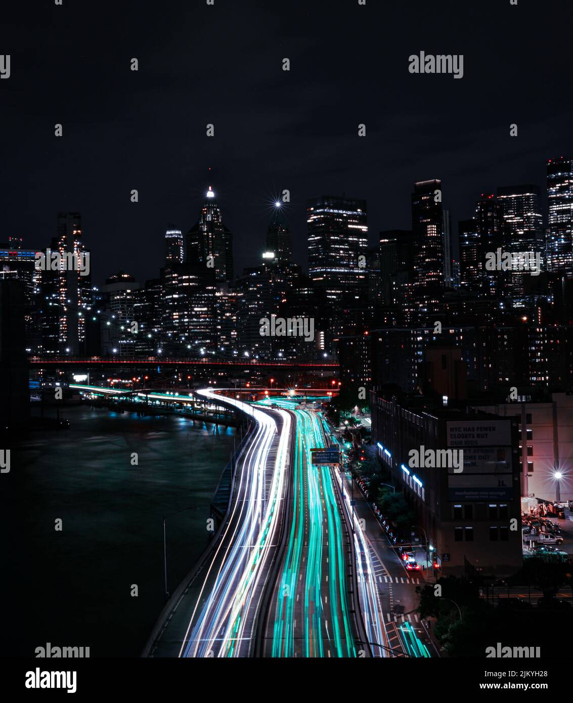 I sentieri leggeri di automobili su una strada circondata da edifici di notte Foto Stock