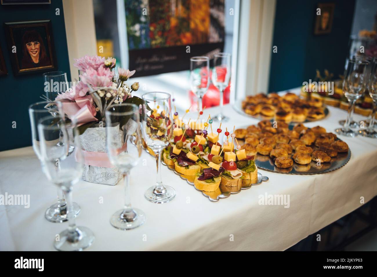 Un poco profondo focus del buffet ben organizzato da un servizio di catering con bicchieri da vino sul tavolo Foto Stock