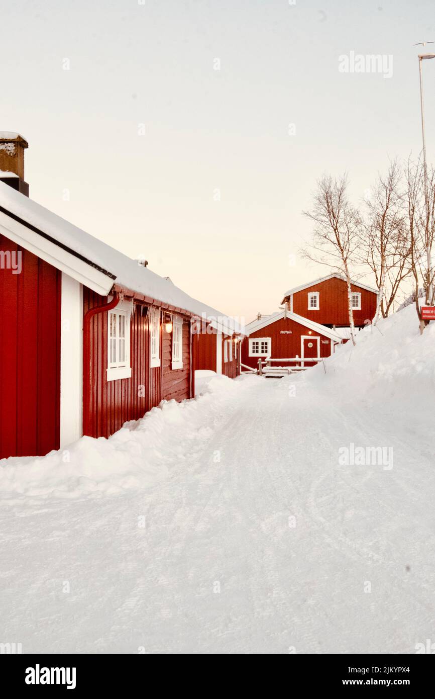 Un colpo verticale di cabine rosse su un campo nevoso a Islas Lofoten, Norvegia Foto Stock