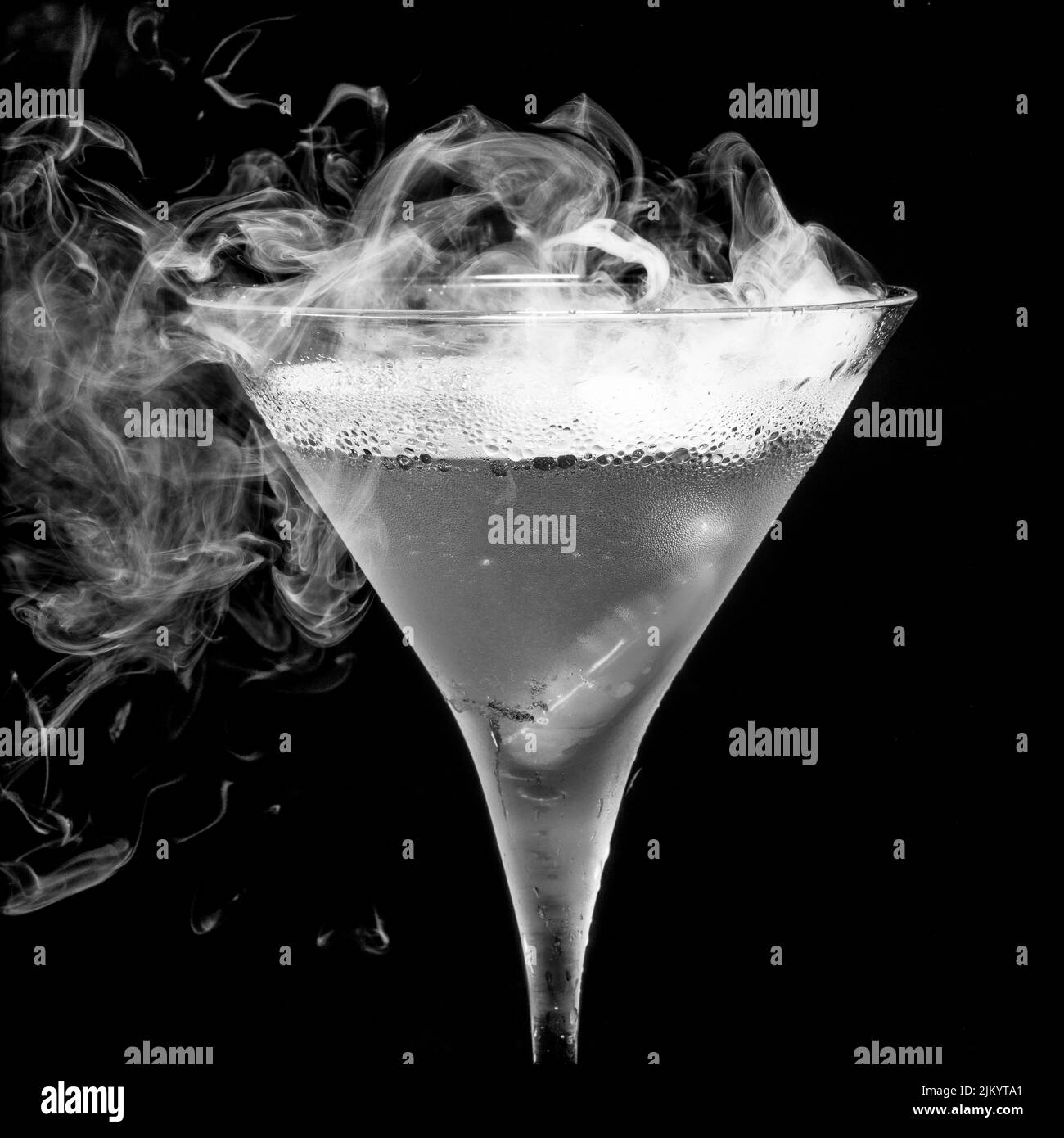 Uno shot in scala di grigi di un bicchiere di aperitivo freddo su sfondo nero Foto Stock