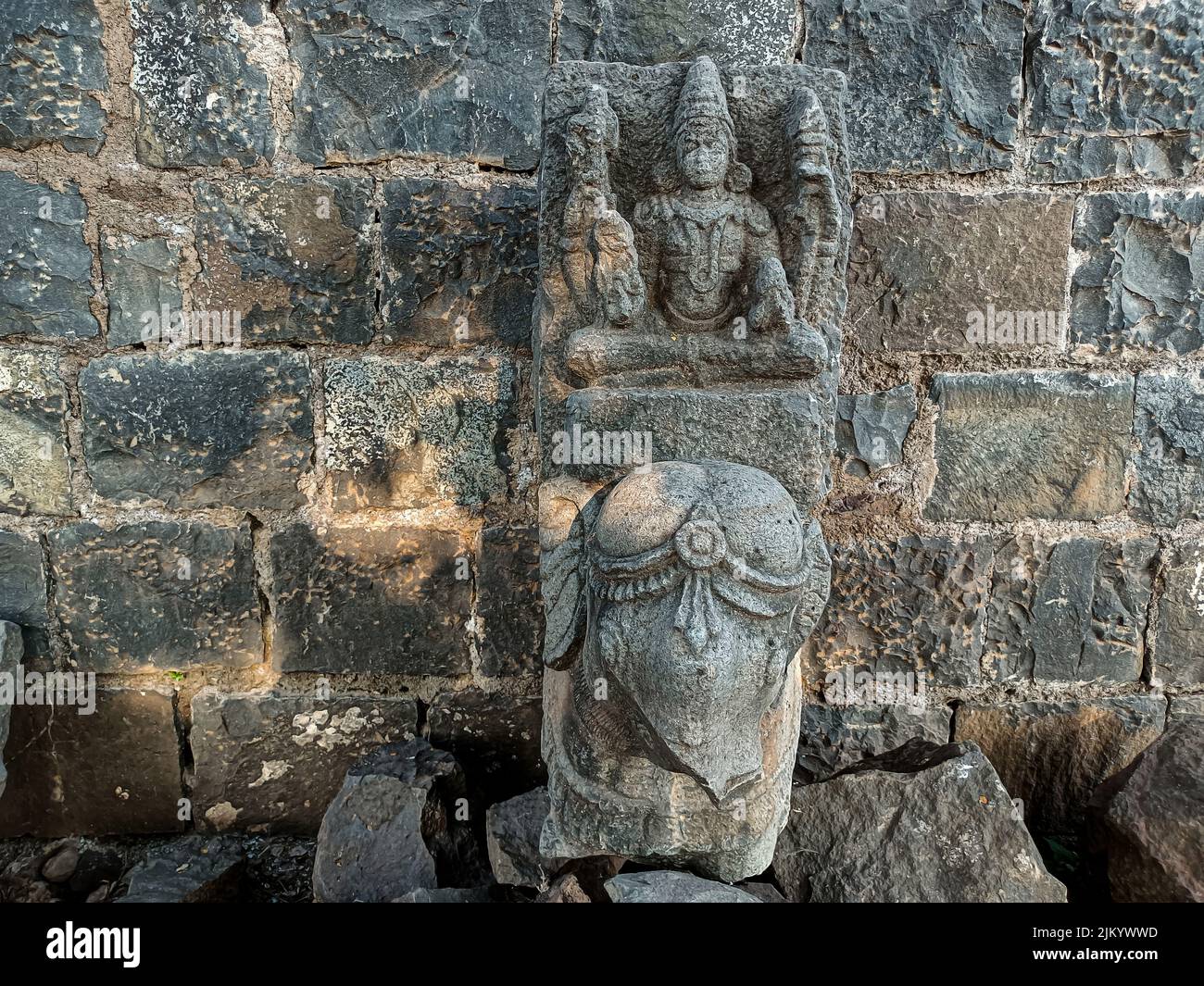 Foto di scorta di scultura antica rovinata di Dio della trinità indù seduto su elefante, idolo scolpito fuori gary colore granito luce del sole cadere su idolo, Pic Foto Stock