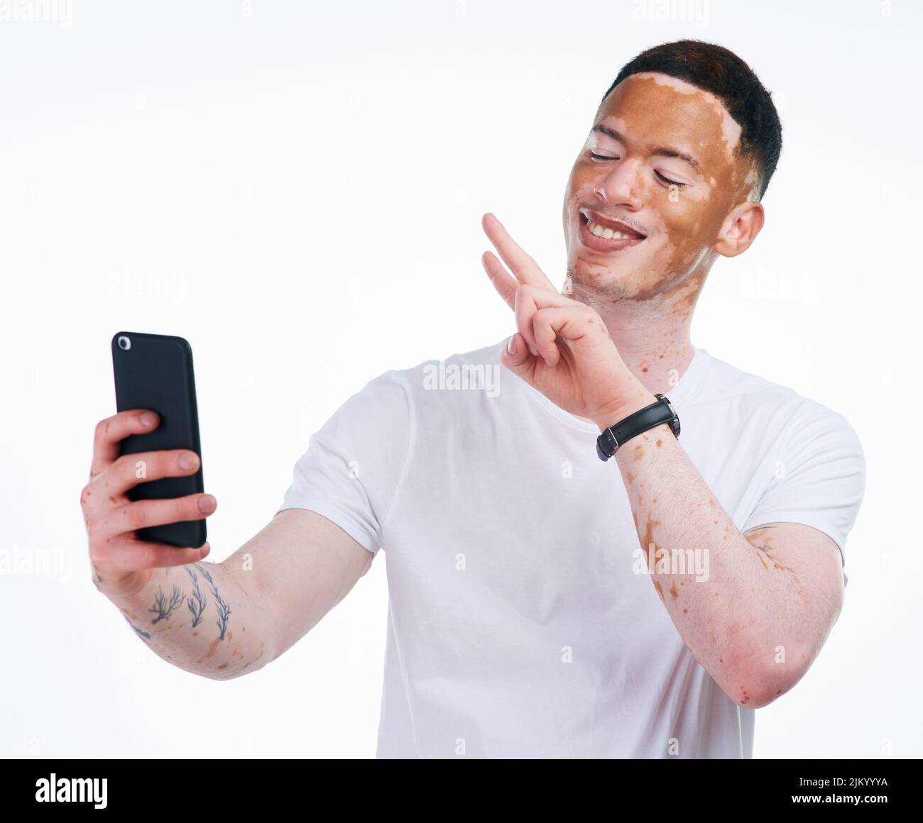 Im non diverso, im edizione limitata. Ritratto di un bel giovane uomo con vitiligo prendendo un selfie con un telefono cellulare su sfondo bianco. Foto Stock