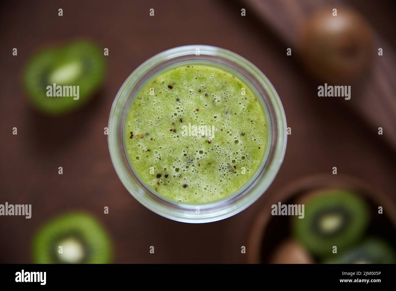 Migliora il tuo cibo per aumentare il tuo umore. Scatto in testa di un kiwi frullato su un asse di legno. Foto Stock