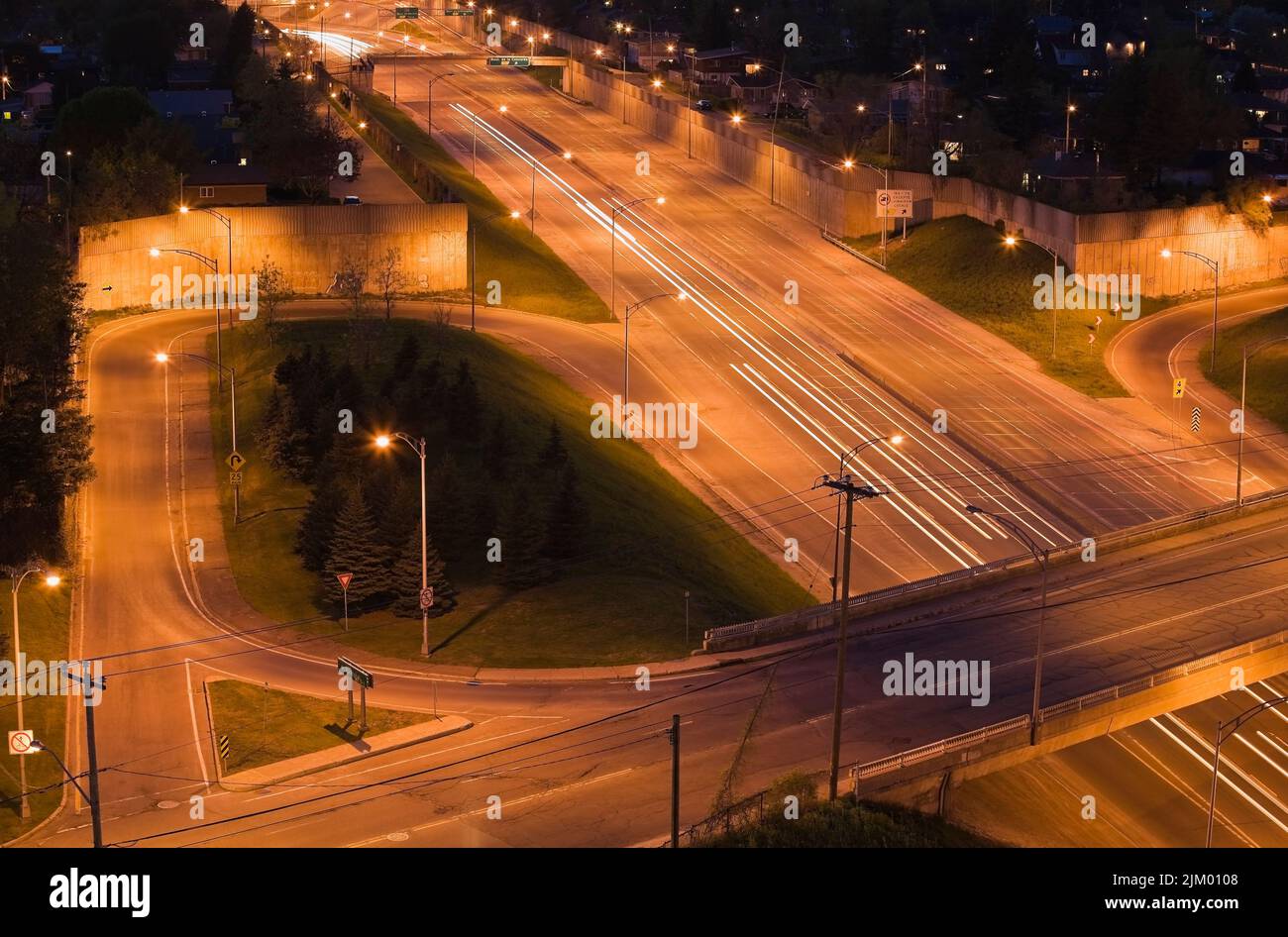 Vista dall'alto dell'autostrada 19 con un cavalcavia e le rampe di accesso e uscita al crepuscolo, Laval, Quebec, Canada. Foto Stock